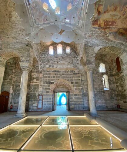 Trabzon Ayasofya’nın iç mekanı, Komnenos döneminin taş işçiliğini ve günümüze ulaşan fresk izlerini bir arada hissettiren sade ama etkileyici bir atmosfer sunar. Aydınlatmalı cam zemin altında ise yapının erken dönem döşeme kalıntıları görülebilir.